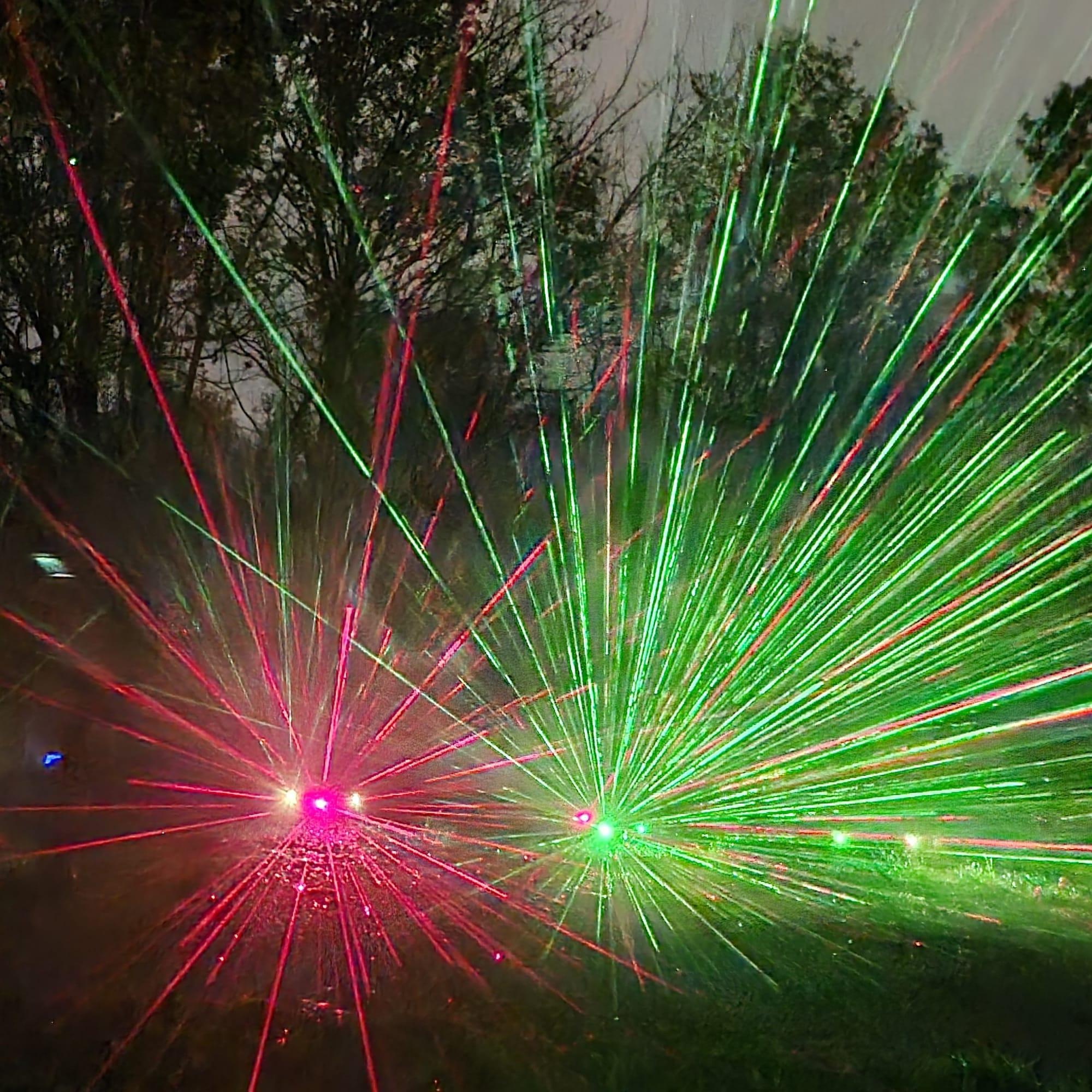 Red and green laser garden effect through trees